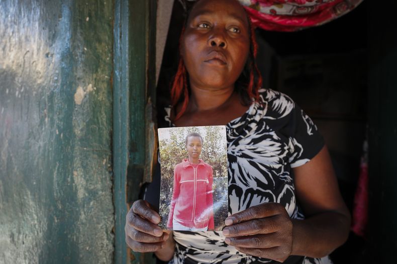 ARCHIVO - Rose Wanyua Wanjiku, hermana mayor de Agnes Wanjiru, de 20 años, sostiene una fotografía de Agnes, en la casa de Rose en el asentamiento informal de Majengo en Nanyuki, Kenia, el jueves 4 de noviembre de 2021. (AP Foto/Brian Inganga)