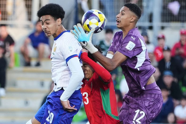 El portero de Marruecos Ibrahim Gomis atrapa el balón frente a su compañero Taha Majni y el francés Djylian Nguessan en las semifinales de la Copa Mundial Sub-20 el miércoles 15 de agosto del 2025. (AP Foto/Andre Penner)