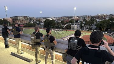 Agentes del Departamento de Policía Metropolitana, del FBI y de Investigaciones de Seguridad Nacional (HIS, por sus siglas en inglés), vigilan un juego de fútbol americano entre Bell Multicultural y Archbishop Carroll, el viernes 12 de septiembre de 2025, en la Secundaria Cardozo en el vecindario de Columbia Heights de Washington. (AP Foto/Pablo Martinez Monsivais)