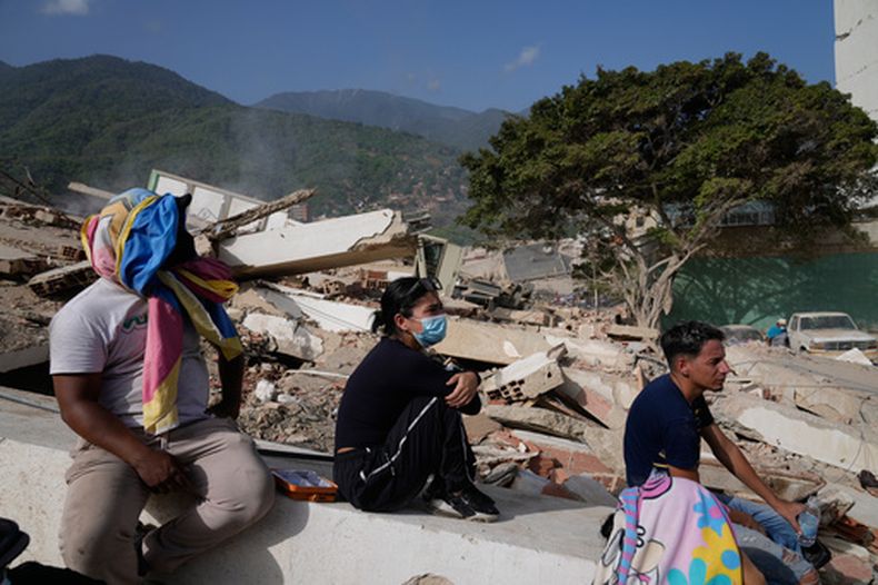 Residentes se sientan cerca de sus casas destruidas dos días después del sismo que azotó La Guaira, Venezuela, el viernes 26 de junio de 2026. (Foto AP/Ariana Cubillos)
