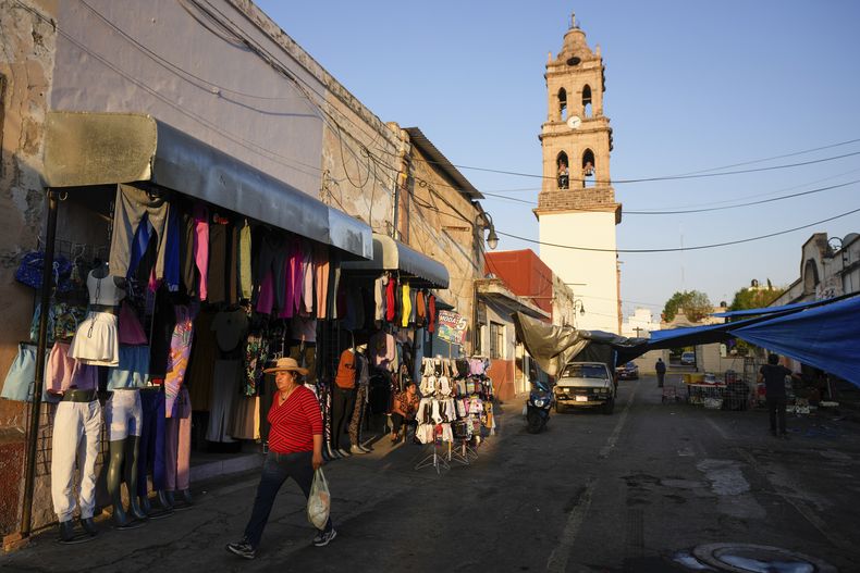 Una mujer camina en Maravatío, en el estado de Michoacán, México, el martes 27 de febrero de 2024. Dos aspirantes a alcalde en esa localidad murieron baleados el día anterior con unas horas de diferencia. (AP Foto/Fernando Llano)