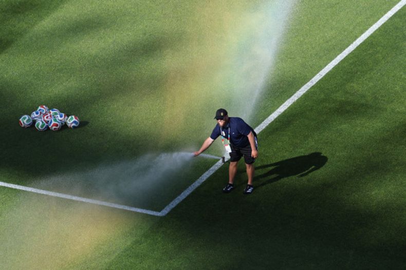 Un empleado de la cancha coloca su mano en un aspersor antes del partido del Mundial entre Irak y Noruega, el martes 16 de junio de 2026 en Foxborough, Massachusetts (AP Foto/Mark Stockwell)