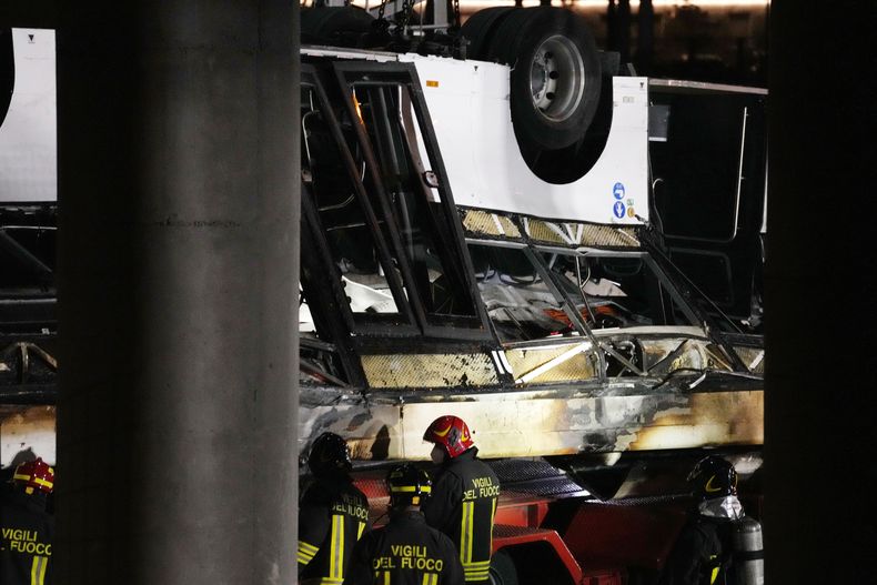 Bomberos italianos trabajan en el lugar del accidente de un autobús de pasajeros en Mestre, cerca de la ciudad de Venecia, Italia, miércoles 4 de octubre de 2023. El autobús cayó desde una carretera elevada, a última hora del martes, matando a varias personas. (AP Foto/Antonio Calanni)
