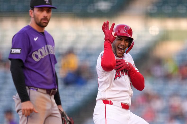 El dominicano José Siri, de los Angelinos de Los Ángeles, festeja luego de batear un doble productor, detrás de Edouard Julien, de los Rockies de Colorado, el miércoles 3 de junio de 2026 (AP Foto/Mark J. Terrill)
