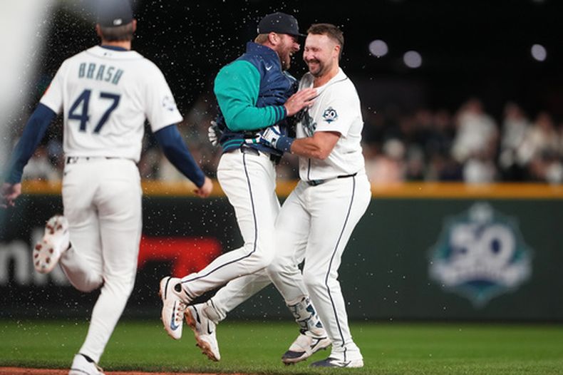 Luke Raley, de los Marineros de Seattle, celebra con Cal Raleigh, a la derecha, tras el sencillo de Raleigh para ganar el juego contra los Yankees de Nueva York después de un juego de béisbol, el lunes 30 de marzo de 2026, en Seattle. (Foto AP/Lindsey Wasson)