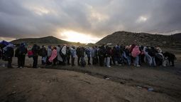 ARCHIVO - Migrantes que desean solicitar asilo en Estados Unidos hacen cola en un campamento improvisado para ser procesados por las autoridades tras cruzar la frontera con México, el viernes 2 de febrero de 2024, cerca de Jacumba Hot Springs, California. (AP Foto/Gregory Bull, Archivo)