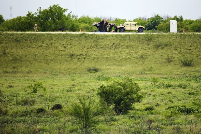 Dos miembros de la Guardia Nacional patrullan un área de tierra detrás del muro fronterizo federal la tarde del martes 19 de marzo de 2024, en Mission, Texas. (AP Foto/Valerie Gonzalez)