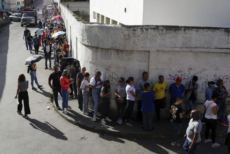 Venezolanos hacen fila afuera de un centro de votación durante la elección presidencial en Caracas, Venezuela, el domingo 28 de julio de 2024. (AP Foto/Cristian Hernández)