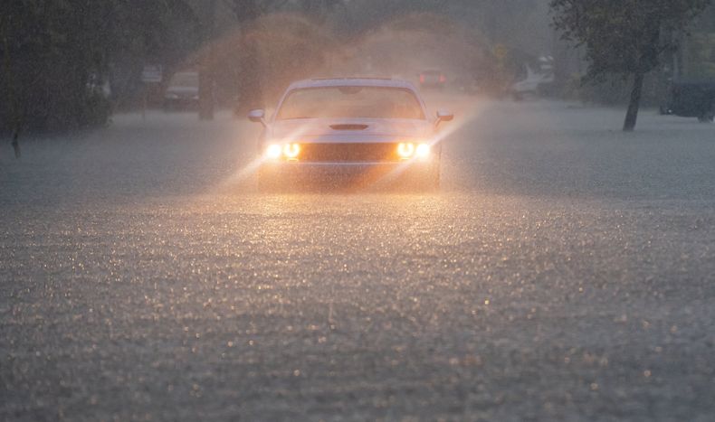 Un conductor parpadea sus luces de emergencia mientras cae una fuerte lluvia sobre partes del sur de Florida, el miércoles 12 de junio de 2024, en Hollywood, Florida. (Matias J. Ocner/Miami Herald via AP)