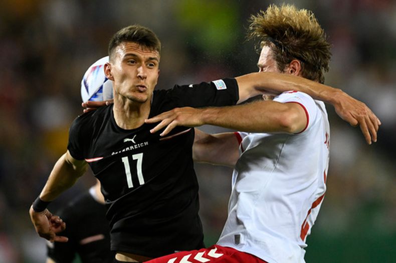 ARCHIVO - El austriaco Dejan Ljubicic (izquierda) y el danés Joachim Andersen pugnan por el balón en un partido de la Liga de Naciones de la UEFA, el 6 de junio de 2022, en Viena. (AP Foto/Andreas Schaad)