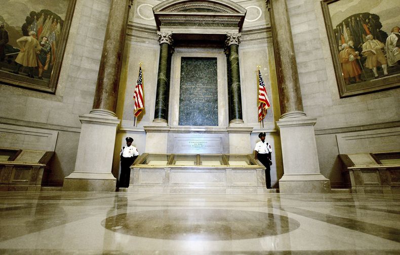 ARCHIVO - Agentes de seguridad junto a la Constitución de Estados Unidos en la recién renovada Rotonda de los Archivos Nacionales de Washington, el 16 de septiembre de 2003, durante una presentación a los medios de comunicación. (AP foto/Ron Edmonds)