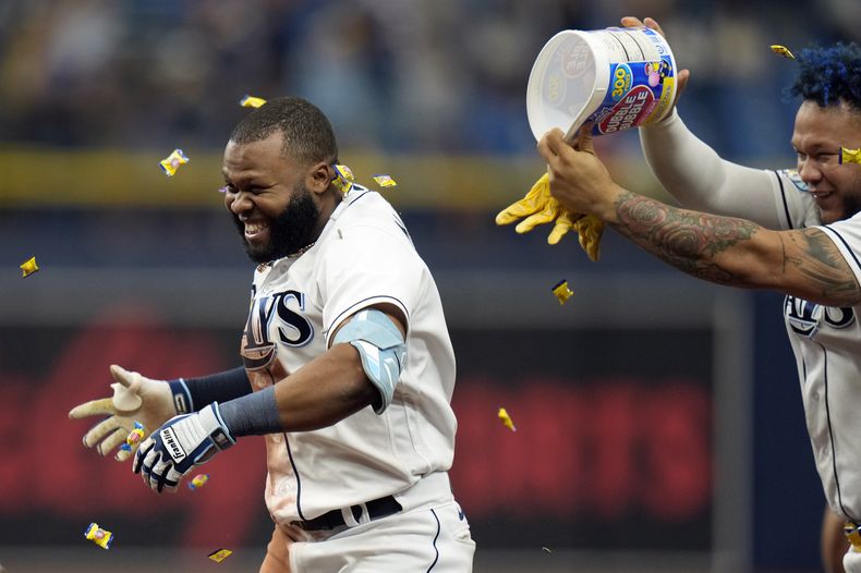 El dominicano de los Rays de Tampa Bay Manuel Margot cubierto con goma de mascar por el colombiano Harold Ramírez tras el sencillo con anotación para el triunfo ante el relevista de los Angelinos de Los Ángeles Carlos Estévez el jueves 21 de septiembre del 2023. (AP Foto/Chris OMeara)