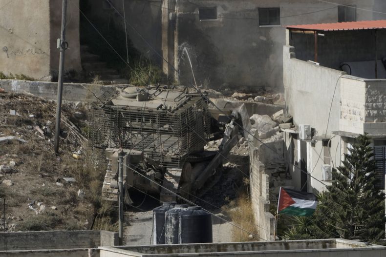 Un bulldozer del ejército israelí avanza por la localidad de Qabatiya, en Cisjordania, durante una redada de las fuerzas armadas de Israel el jueves 19 de septiembre de 2024. (AP Foto/Majdi Mohammed)