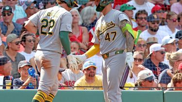 Jeff McNeil (22), de los Atléticos, saluda a su compañero Tommy White (47) tras anotar durante la octava entrada de un partido de béisbol contra los Medias Rojas de Boston, el domingo 9 de agosto de 2026, en Boston. (Foto AP/Mark Stockwell)