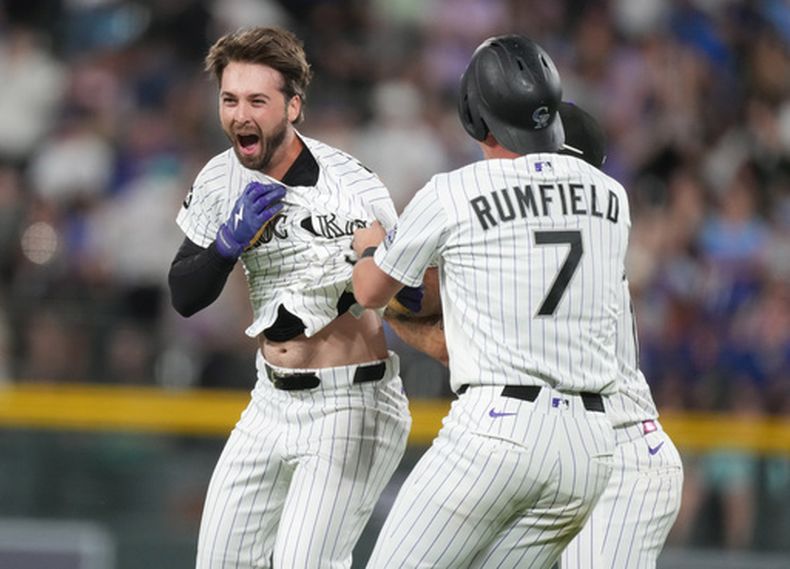El bateador emergente Sterlin Thompson, izquierda, de los Rockies de Colorado, es felicitado después de decidir el partido con un sencillo que remolcó a TJ Rumfield, en la novena entrada del juego de béisbol de Grandes Ligas ante los Cachorros de Chicago, el miércoles 10 de junio de 2026, en Denver. (AP Foto/David Zalubowski)