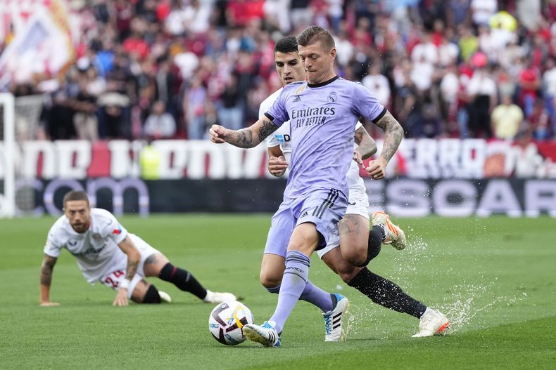 Toni Kroos (derecha) del Real Madrid se adelanta a Erik Lamela del Sevilla en un partido de la Liga española, el sábado 27 de mayo de 2023, en Sevilla. (AP Foto/José Bretón)