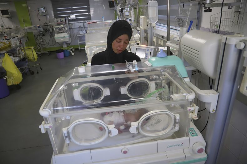 Seham Fawzy Khodeir observa a su hijo, Hisham, que nació prematuramente y sólo ha vivido unos días, dentro de una incubadora en la unidad de terapia intensiva para recién nacidos del hospital Nasser, el jueves 19 de junio de 2025, en Jan Yunis, en el sur de la Franja de Gaza. (AP Foto/Mariam Dagga)
