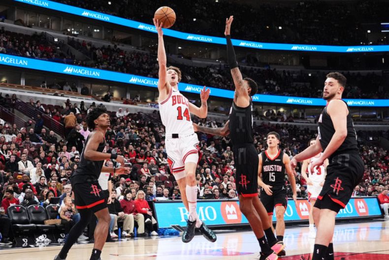 Matas Buzelis (14), de los Bulls de Chicago, se alista para encestar sobre Jabari Smith Jr., centro derecha, de los Rockets de Houston, durante la primera mitad del juego de baloncesto de la NBA, el lunes 23 de marzo de 2026, en Chicago. (AP Foto/Nam Y. Huh)