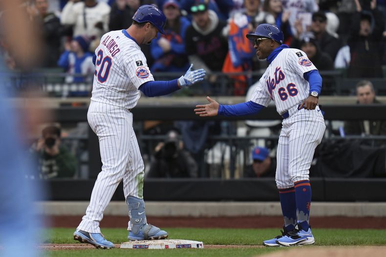 Pete Alonso de los Mets de Nueva York celebra su sencillo remolcador con el entrenador de primera base Antoan Richardson en la tercera entrada del juego ante los Azulejos de Toronto el domingo 6 de abril del 2025. (AP Foto/Seth Wenig)