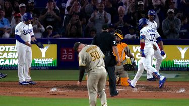 Teoscar Hernández (derecha), de los Dodgers de Los Ángeles, anota tras conectar un grand slam mientras Max Muncy (izquierda) lo espera y el lanzador de los Padres de San Diego, Adrián Morejón, permanece en el montículo durante la séptima entrada de un partido de béisbol, el viernes 3 de julio de 2026, en Los Ángeles. (Foto AP/Mark J. Terrill)