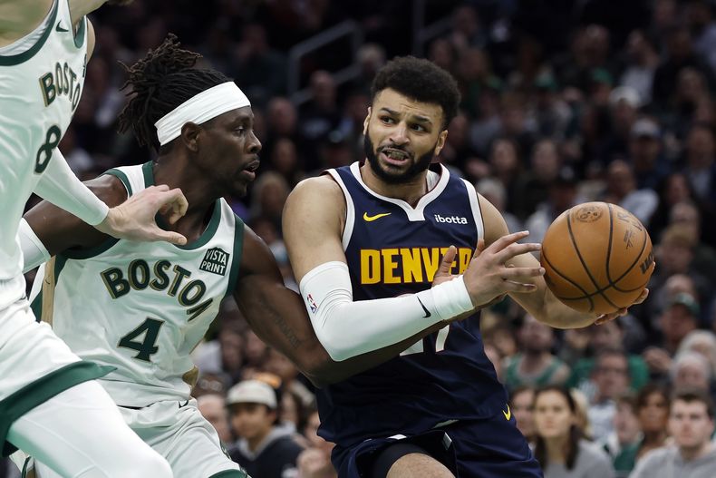 Jamal Murray (27), de los Denver Nuggets, supera a Jrue Holiday (4), de los Boston Celtics, durante la segunda mitad del partido de baloncesto de la NBA, el viernes 19 de enero de 2024, en Boston. (AP Foto/Michael Dwyer)