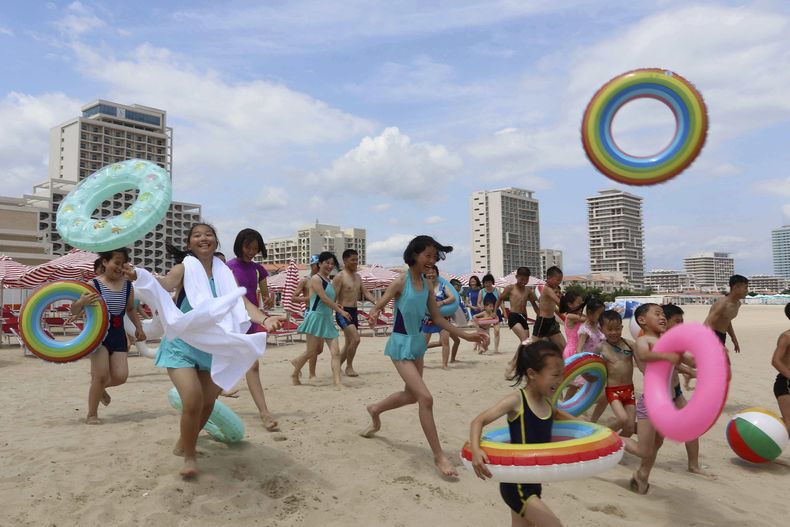 Niños corren hacia el mar en el balneario turístico de Wonsan-Kalma, en Wonsan, en la provincia norcoreana de Kangwon, el 2 de julio de 2025. (AP Foto/Jon Chol Jin)