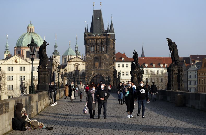 ARCHIVO – Varias personas cruzan el puente medieval Carlos en Praga, república Checa, el 25 de febrero de 2021. (AP Foto/Petr David Josek, Archivo)