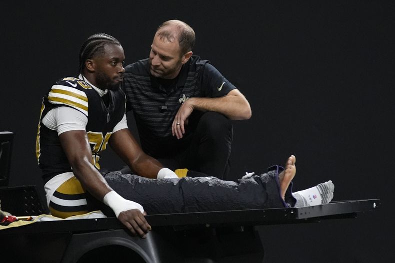 Paulson Adebo, cornerback de los Saints de Nueva Orleáns, es retirado del terreno tras lastimarse durante la primera mitad del partido ante los Broncos de Denver, el jueves 17 de octubre de 2024 (AP Foto/Gerald Herbert)