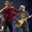 ARCHIVO - Mick Jagger, en el centro, Ronnie Wood, a la izquierda, y Mick Taylor, de la banda de rock británica The Rolling Stones, actúan en el escenario principal de la Pirámide en Glastonbury, Inglaterra, el 29 de junio de 2013. (Joel Ryan/Invision/AP, archivo)