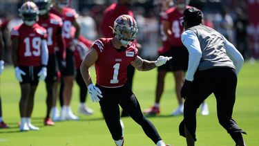 El receptor de los 49ers de San Francisco Ricky Pearsall corre durante un ejercicio con el entrenador de receptores Leonard Hankerson en el campamento de entrenamiento el lunes 27 de julio del 2026. (AP Foto/Jeff Chiu)