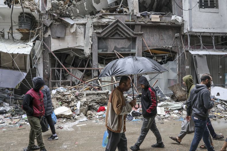 Varios palestinos caminan en la Ciudad de Gaza el lunes 27 de noviembre de 2023, el cuarto día de un cese del fuego temporal entre Hamás e Israel. (AP Foto/Mohammed Hajjar)