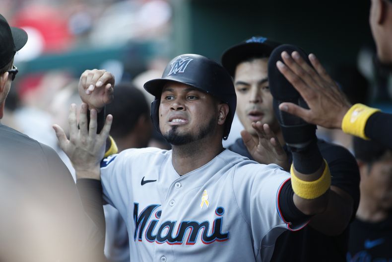Luis Arráez, de los Marlins de Miami, celebra con sus compañeros de equipo después de anotar la carrera de la ventaja con un error del los Nacionales de Washington durante la novena entrada del juego de béisbol del domingo 3 de septiembre de 2023, en Washington. (AP Foto/Luis M. Alvarez)
