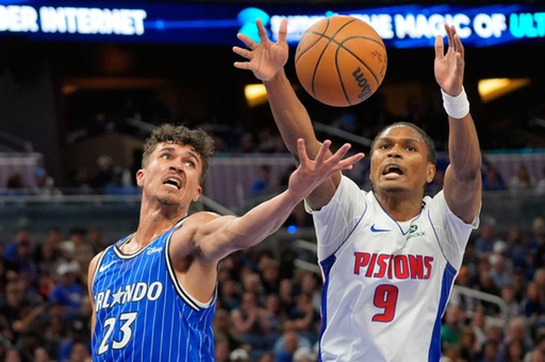 Tristan da Silva (23), del Magic de Orlando, y Ausar Thompson (9), de los Pistons de Detroit, disputan la posesión del balón durante la primera mitad del juego de baloncesto de la NBA, el domingo 1 de marzo de 2026, en Orlando, Florida. (AP Foto/John Raoux)