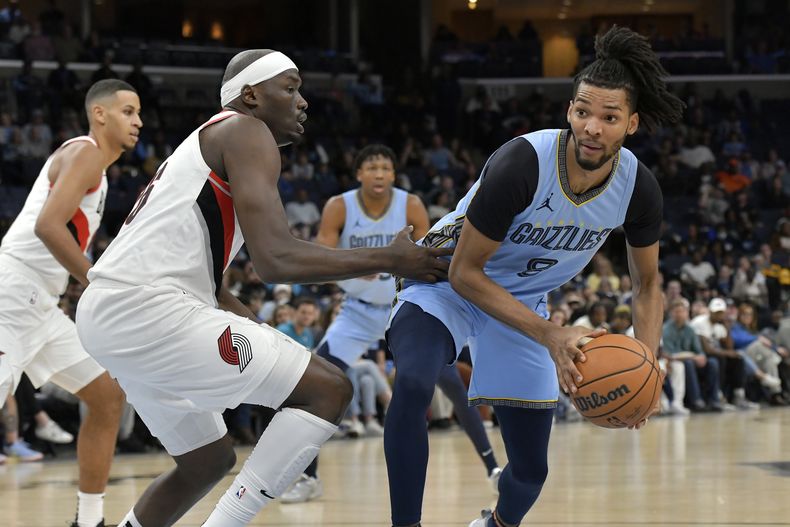 El alero de los Grizzlies de Memphis, Ziaire Williams (8), contra el pívot de los Trail Blazers de Portland, Duop Reath, durante la primera mitad del partido de baloncesto de la NBA, el sábado 2 de marzo de 2024, en Memphis, Tennessee.
