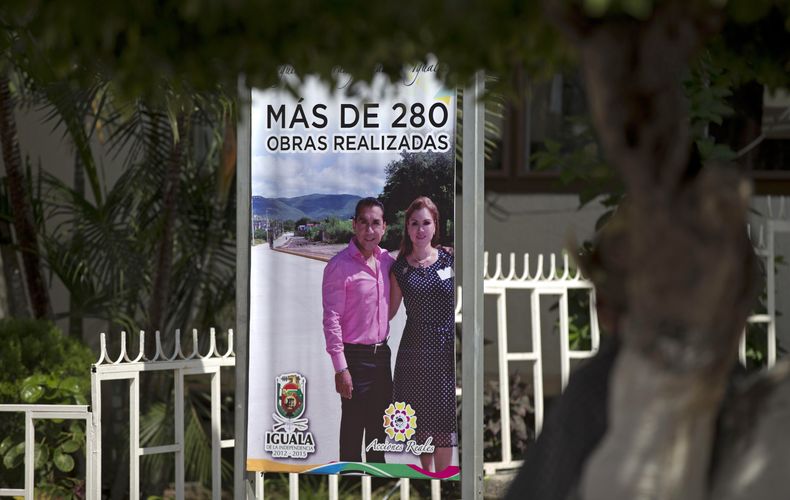 ARCHIVO - Un letrero promueve proyectos de la ciudad con el alcalde José Luis Abarca y su esposa frente a las oficinas municipales en Iguala, México, el 7 de octubre de 2014. Abarca ha sido exonerado por el secuestro de 43 estudiantes de Ayotzinapa, desaparecidos en Iguala en julio de 2014, anunció el presidente de México el miércoles 31 de mayo de 2023. (AP Foto/Eduardo Verdugo, Archivo)