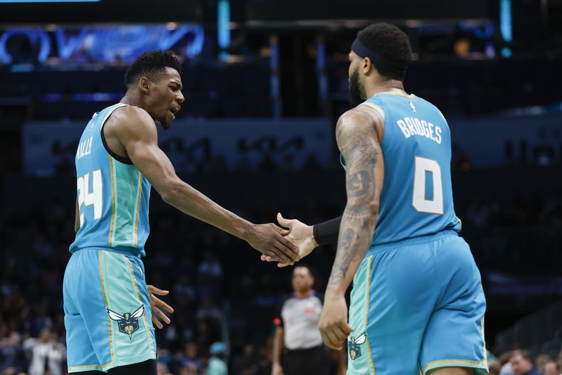 Brandon Miller (izquierda) y Miles Bridges, de los Hornets de Charlotte, festejan durante los últimos segundos del partido ante los Cavaliers de Cleveland, el miércoles 27 de marzo de 2024 (AP Foto/Nell Redmond)