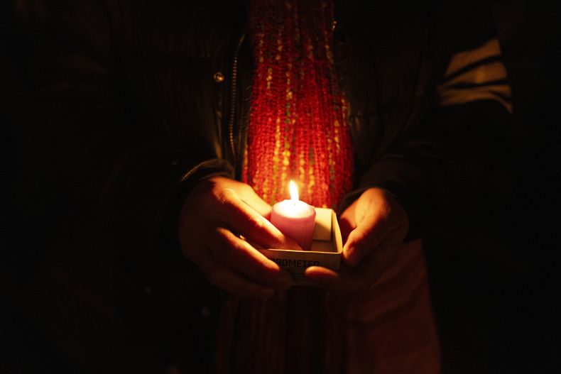 Una amiga sostiene una vela mientras recuerda a Mackenzie Michalski, una turista estadounidense de 31 años que fue asesinada mientras estaba de vacaciones, durante una vigilia con velas en Budapest, Hungría, el sábado 9 de noviembre de 2024. (Foto AP/Bela Szandelszky)