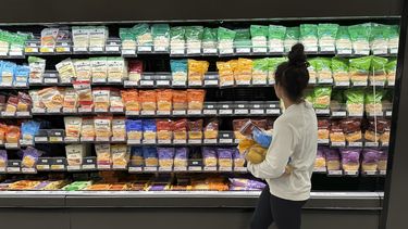 ARCHIVO - Una mujer revisa las ofertas de quesos en una tienda de la cadena Target, el 4 de octubre de 2023, en Sheridan, Colorado. (AP Foto/David Zalubowski, archivo)