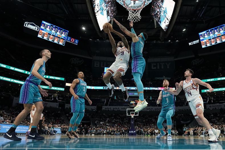 Bradley Beal, de los Suns de Phoenix, ataca la canasta ante la marca defensiva de Miles Bridges, de los Hornets de Charlotte, durante la segunda mitad del juego de baloncesto de la NBA, el viernes 15 de marzo de 2025, en Charlotte, Carolina del Norte. (AP Foto/Chris Carlson)