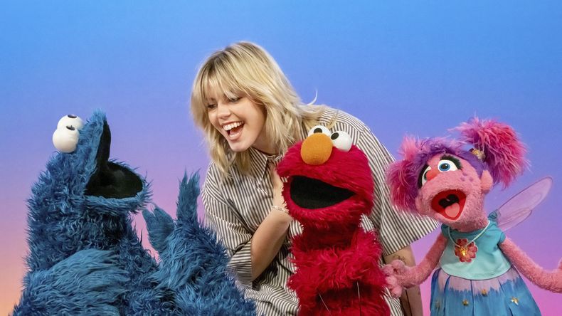 Esta imagen proporcionada por Sesame Workshop muestra la actriz y cantante Renee Rapp con los personajes de los muppets Cookie Monster, de izquierda a derecha, Elmo y Abby Cadabby en el set de Sesame Street. (Richard Termine/Sesame Workshop via AP)