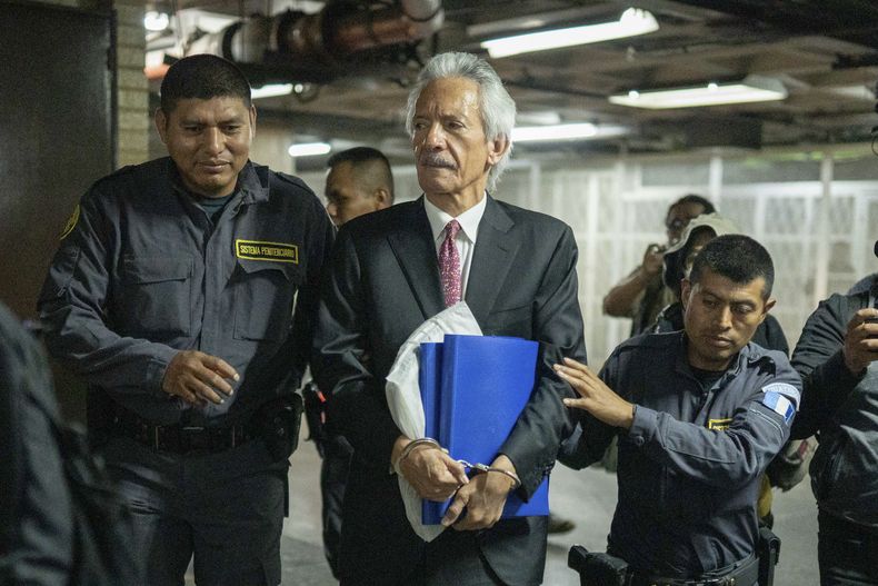 El director y fundador del medio El Periódico, José Rubén Zamora, es escoltado por la policía antes de un audiencia de juicio en Ciudad de Guatemala, el miércoles 14 de junio de 2023. Un tribunal condenó a Zamora a una sentencia de cárcel de seis años en un caso de lavado de dinero. (AP Foto/Santiago Billy)