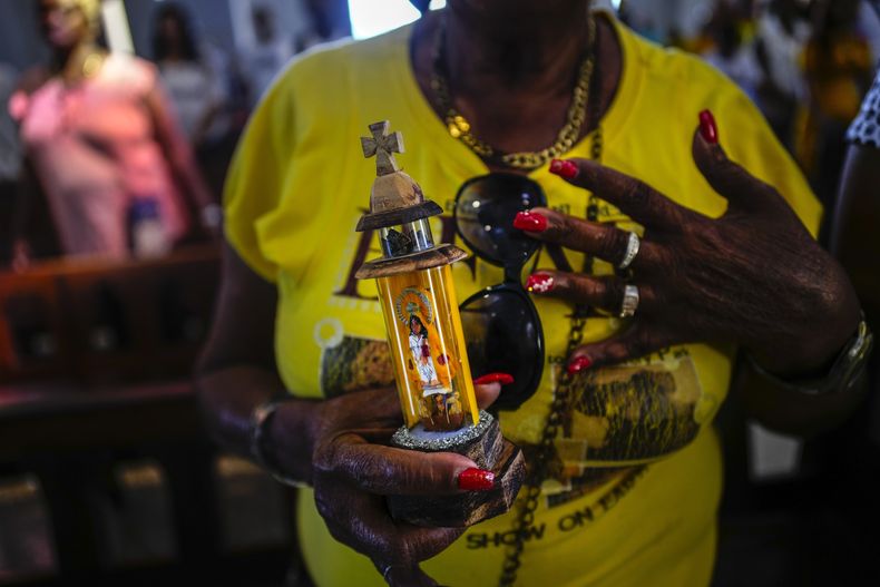 Una persona sostiene una imagen de la Virgen de la Caridad del Cobre durante una misa en su santuario, en El Cobre, Cuba, el 11 de febrero de 2024. La Virgen, reconocida por el Vaticano y venerada por tanto católicos como por seguidores de la tradición afrocubana de la santería, une a los compatriotas en la isla de gobierno comunista y a los exiliados o emigrados. (AP Foto/Ramón Espinosa)