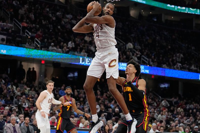 Evan Mobley, pívot de los Cavaliers de Cleveland, atrapa un rebote frente a Jalen Johnson, de los Hawks de Atlanta, el miércoles 8 de abril de 2026 (AP Foto/Sue Ogrocki)