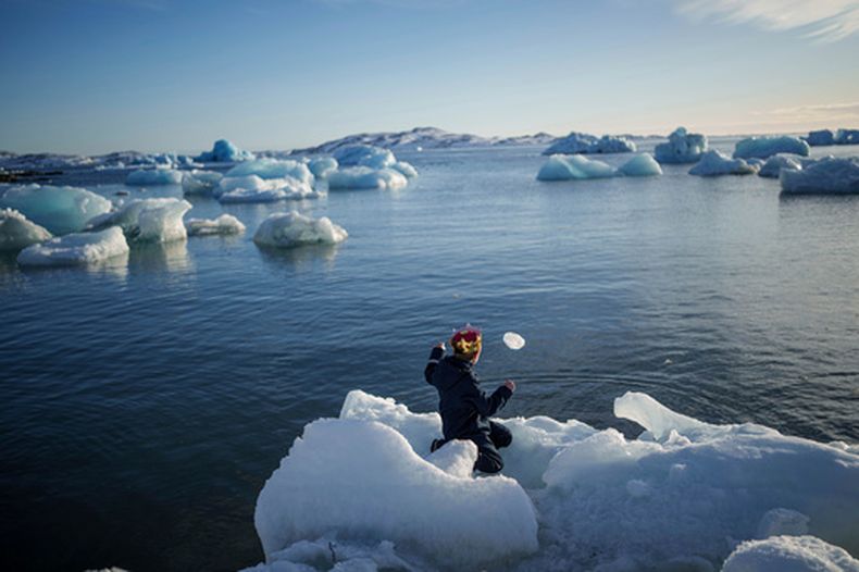 Un niño lanza hielo al mar en Nuuk, Groenlandia, el 11 de marzo de 2025. (Foto AP/Evgeniy Maloletka, Archivo)