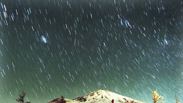 ARCHIVO - La lluvia de meteoritos Leónidas es vista en el cielo sobre el nevado Monte Fuji, la montaña más elevada de Japón, en esta imagen de 7 minutos tomada el 19 de noviembre de 2001. (AP Foto/Itsuo Inouye, archivo)