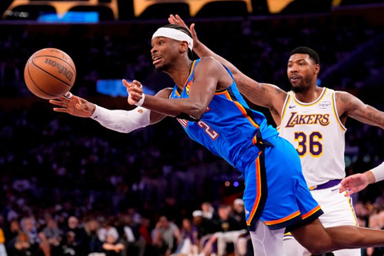 Shai Gilgeous-Alexander, del Thunder de Oklahoma City, envía un pase frente a Marcus Smart, de los Lakers de Los Ángeles, en el tercer partido de la semifinal de la Conferencia Oeste, el sábado 9 de mayo de 2026 (AP Foto/Mark J. Terrill)
