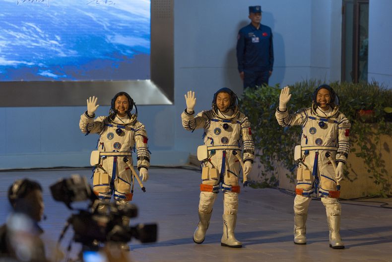 De izquierda a derecha, los astronautas chinos Wang Haoze, Cai Xuzhe y Song Lingdong saludan mientras asisten a la ceremonia de despedida de la misión Shenzhou-19 en el Centro de Lanzamiento de Satélites de Jiuquan, en el noroeste de China, durante las primeras horas del miércoles 30 de octubre de 2024. (Foto AP/Ng Han Guan)
