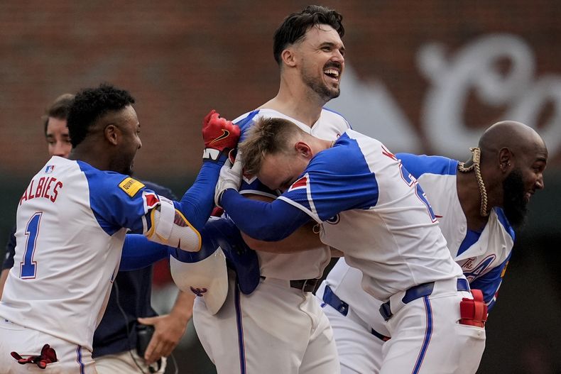 Adam Duvall (centro), de los Bravos de Atlanta, festeja luego de remolcar la carrera del triunfo ante los Piratas de Pittsburgh, el sábado 29 de junio de 2024 (AP foto/Mike Stewart)