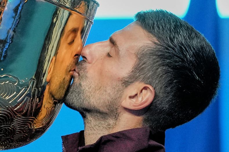 Novak Djokovic besa el trofeo de campeón del Abierto de China tras derrotar a Alex de Miñaur en la final, el martes 6 de octubre de 2026, en Beijing. (AP Foto/Achmad Ibrahim)