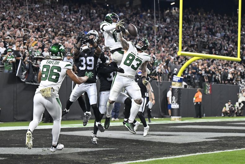 Garrett Wilson, arriba, y Tyler Conklin (83), de los Jets de Nueva York, no pueden quedarse con el balón en un intento de ave María mientras el reloj expiraba durante la segunda mitad del juego de la NFL en contra de los Raiders de Las Vegas, el domingo 12 de noviembre de 2023, en Las Vegas. Los Raiders ganaron 16-12. (AP Foto/David Becker)